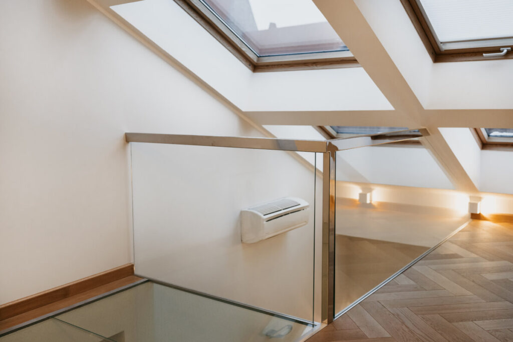 Interior with glass stairwell, pitched ceiling, and skylight windows.