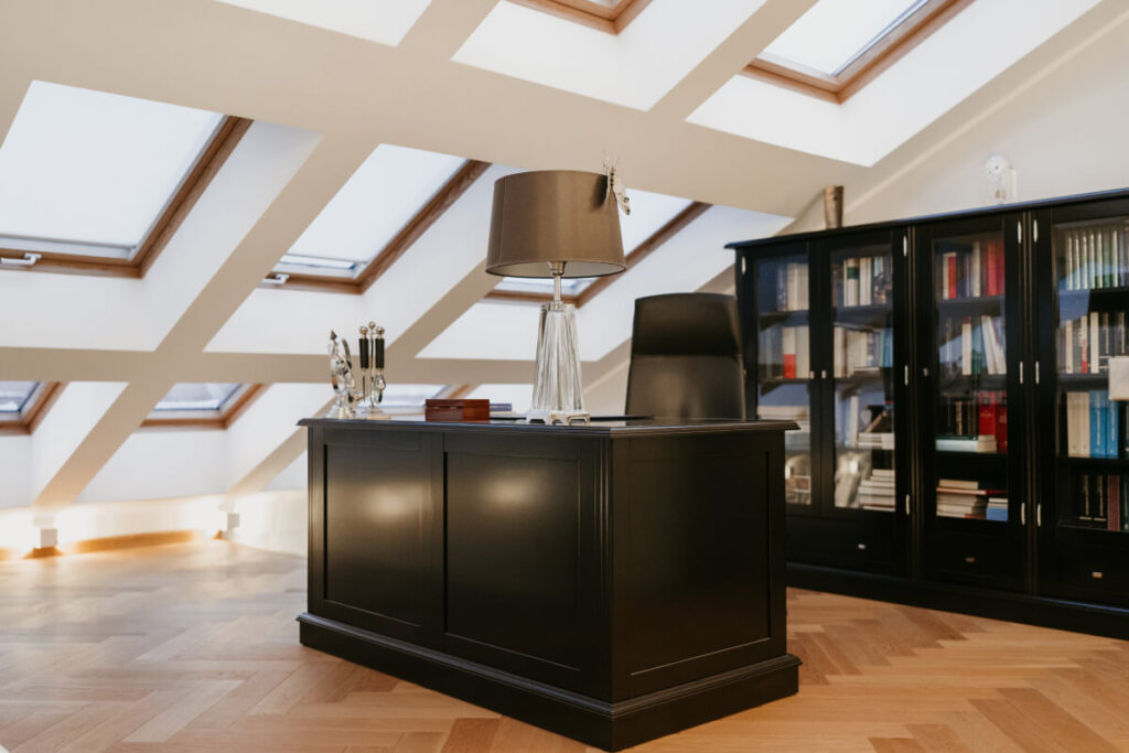 A well-lit home office with a spacious skylight, providing ample natural light for a productive work environment.
