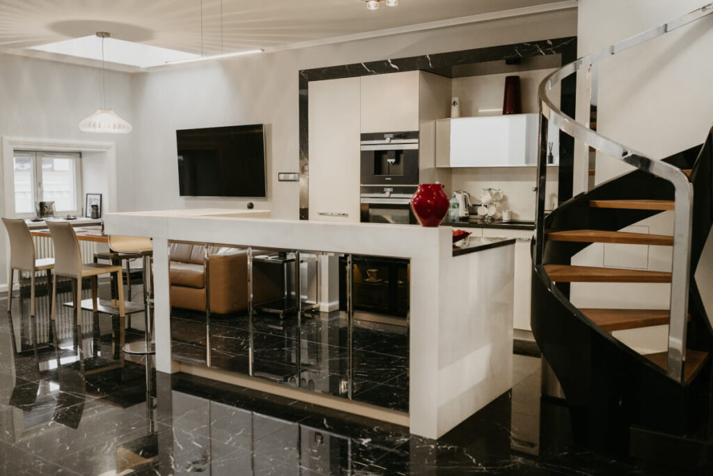 Stylowa kuchnia ze spiralnymi schodami i podłogą z czarnego marmuru.