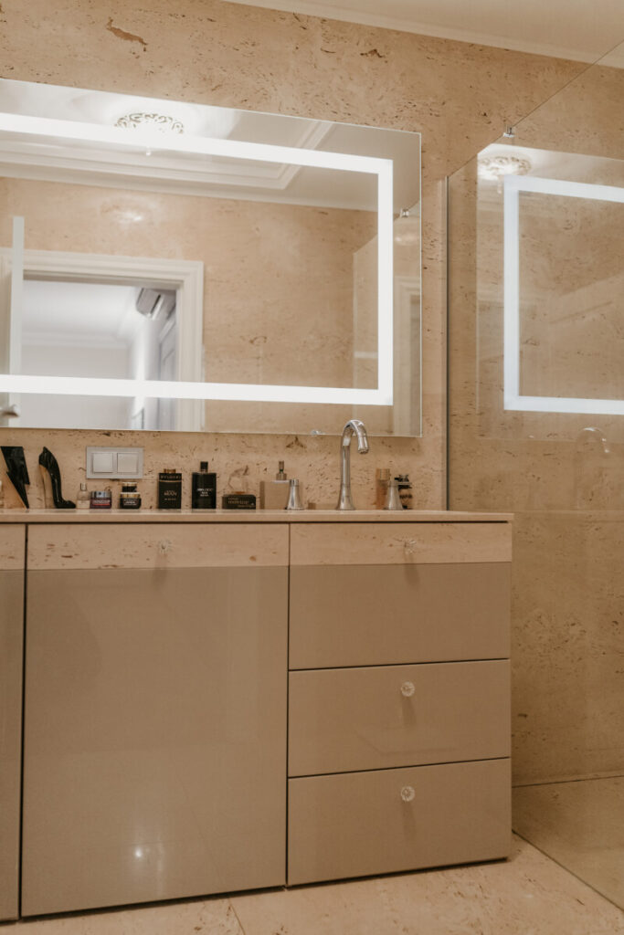 An image of a bathroom with a sink and a large mirror, showcasing contemporary design.An image of a bathroom with a sink and a large mirror, showcasing contemporary design.